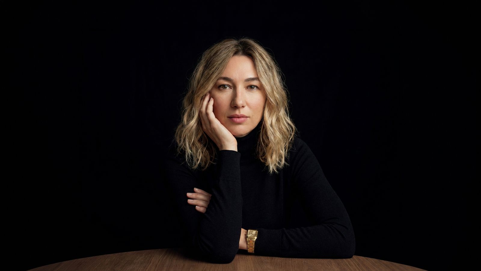 Ioana Lucreția in a black turtleneck, resting her chin on her hand